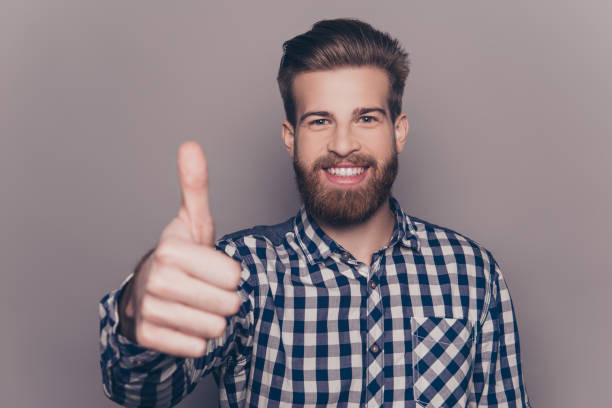 istock Handsome bearded smiling man showing thumb up 945435792