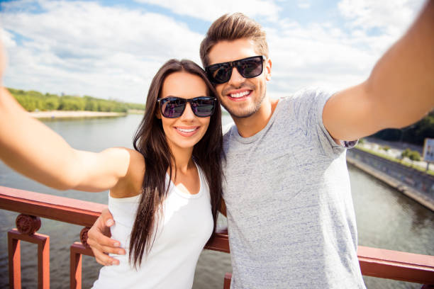istock Cheerful happy man and woman having walk and making selfie 945436128