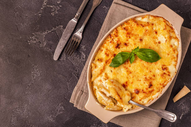 istock Mac and cheese, american style macaroni pasta in cheesy sauce 945436364