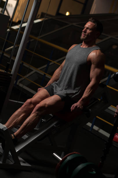 istock Strong man in t-shirt and shorts doing exercises 945436478