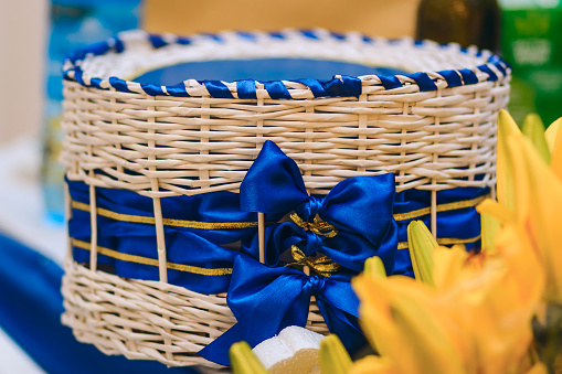 large wicker round basket with blue ribbon and bows