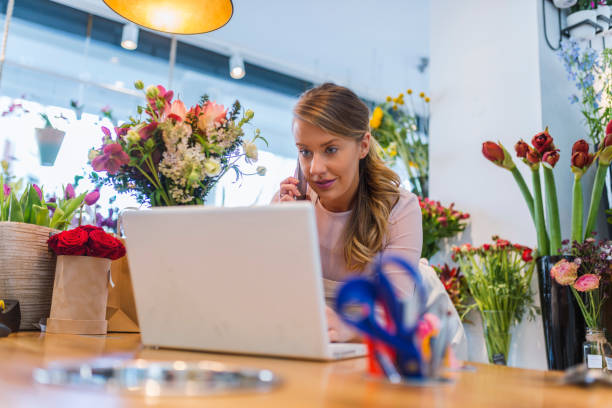 istock Happy florist using technologies at flower shop 945443114