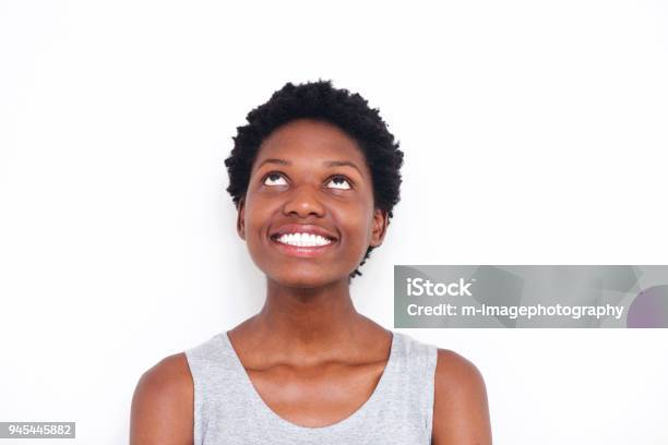 Close Up Young African Woman Looking Up And Smiling On White Background Stock Photo - Download Image Now