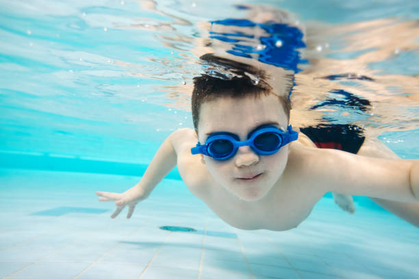 istock Little boy diving in the swimming pool. 945446722