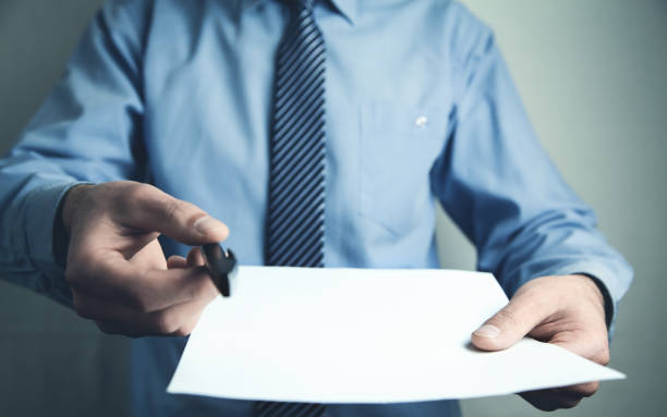 istock Man showing pen and blank paper. 945449560