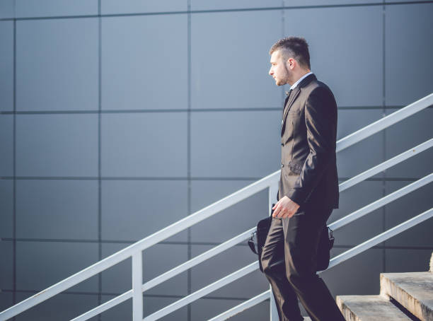 istock Elegant young businessman on stairs. 945450556