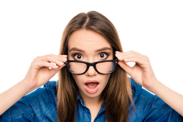 istock Wow! Surprised pretty young brunette touching glasses 945452616