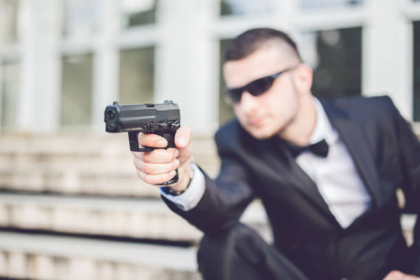 istock Young elegant man with gun outdoor. 945465646