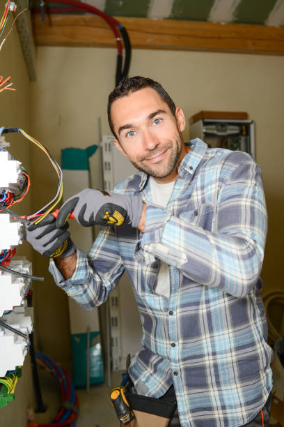 istock handsome young man electrician working on switchboard of house building construction site 945467254