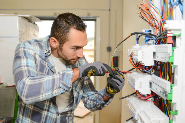 handsome young man electrician working on switchboard of house building construction site