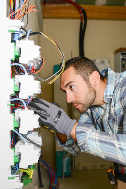 istock handsome young man electrician working on switchboard of house building construction site 945467290