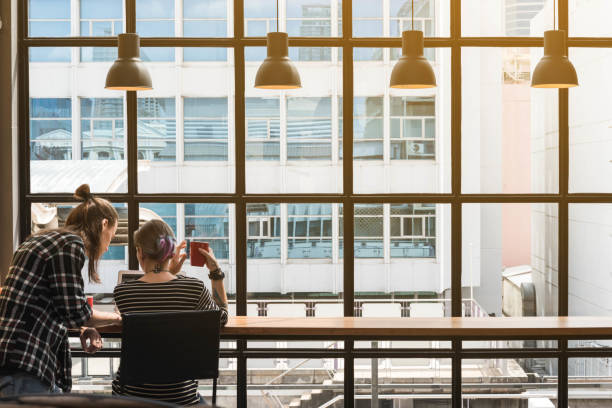 Two freelance working in coffee shop, Nomad worker conceptual, couple having fun work together in cafe stock photo