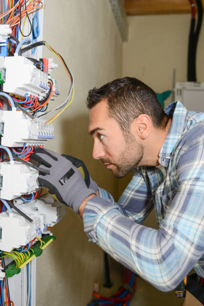 istock handsome young man electrician working on switchboard of house building construction site 945467322