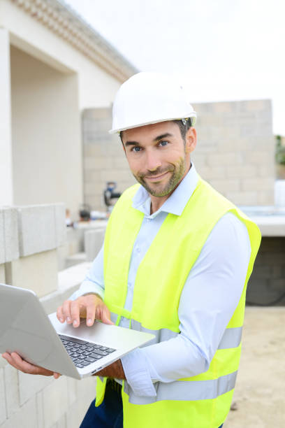 istock handsome young man foreman architect supervising a new house construction site 945467870