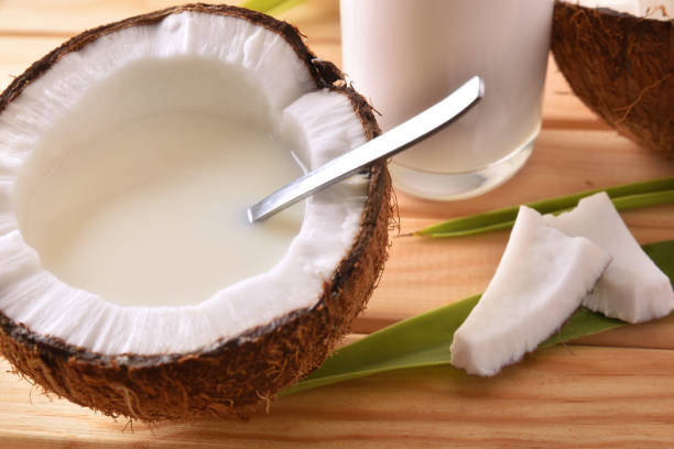 istock Coconut milk in coconut fruit on wooden table close up 945474948
