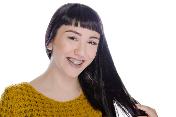 Young woman wearing braces on white background stock photo