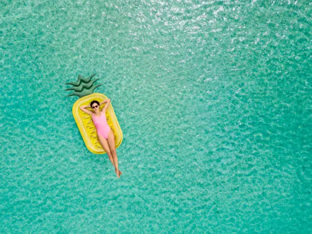 Photo of Carefree woman on inflatable pineapple