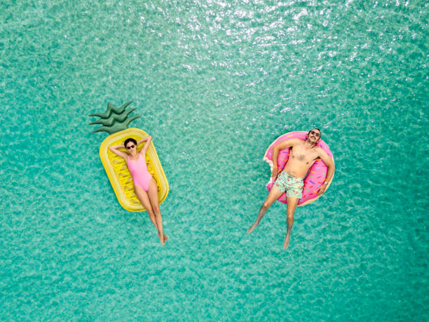 Couple relaxing at the sea Couple relaxing at the sea inflatable ring photos stock pictures, royalty-free photos & images