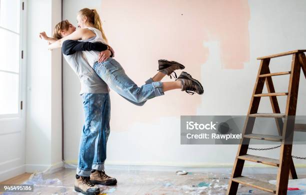 Cheerful Couple Renovating The House Stock Photo - Download Image Now - Couple - Relationship, Renovation, Painting - Activity