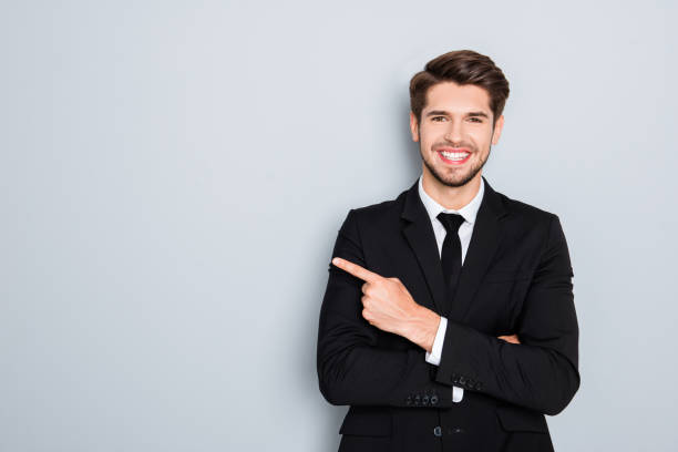 istock Young handsome businessman with beaming smile pointing with finger 945500764