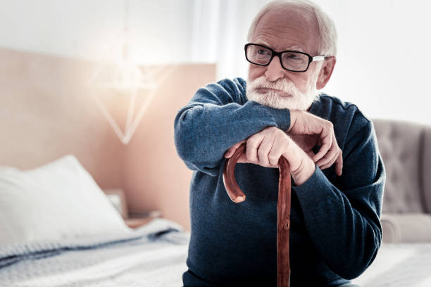 istock Serious thoughtful man leaning on the walking stick 945508488