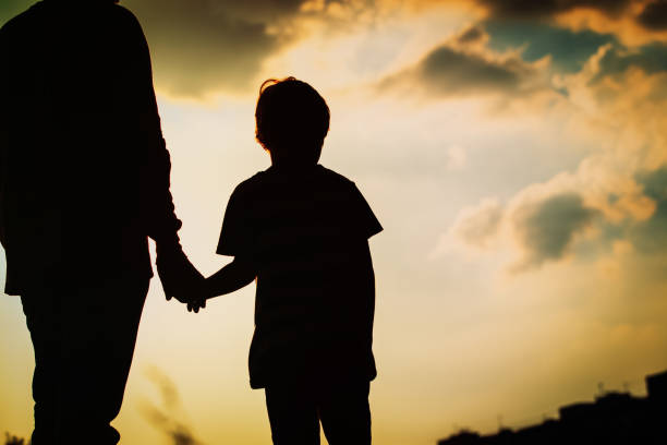 istock silhouette of father and son holding hands at sunset 945520014