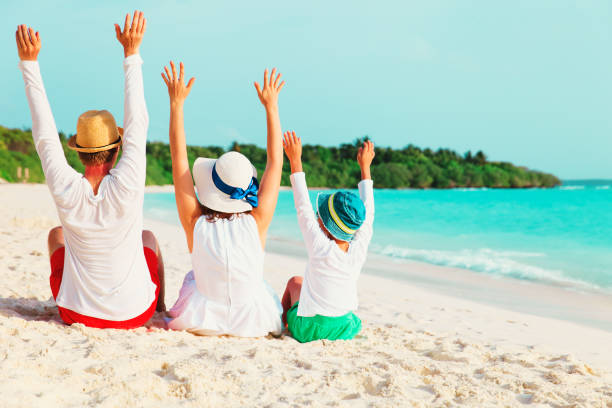 istock happy family with child hands up on beach 945520252