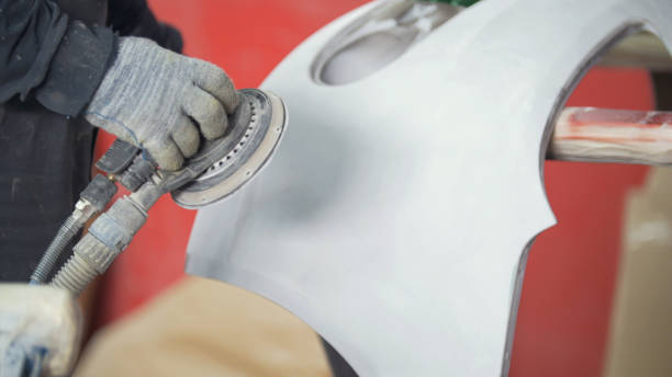 istock Man polishing bumper in a service station garage 945525000