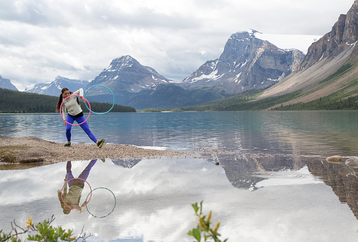 First Nations woman dancing beside mountain lake, Bow Lake, Banff National Park, Alberta