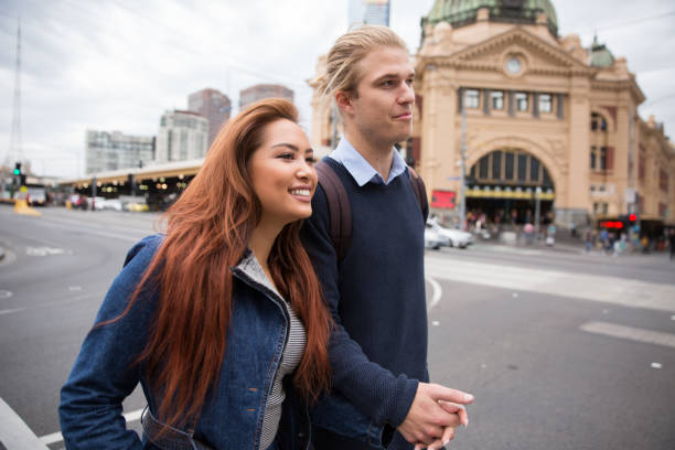istock Couple Walking Across Flinders Street 945535806