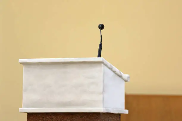 Rostrum with microphone in conference hall or church altar and empty space for text