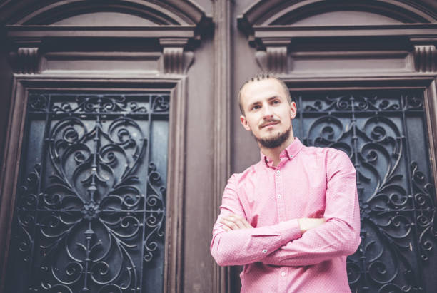 Young modern man in front of massive wooden door.