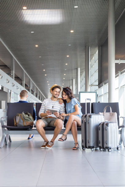 istock Couple waiting for flight at airport lounge 945557576
