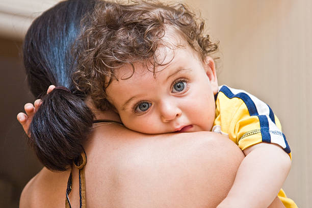 istock little boy on a shoulder at mum, looks in lens. 94555858