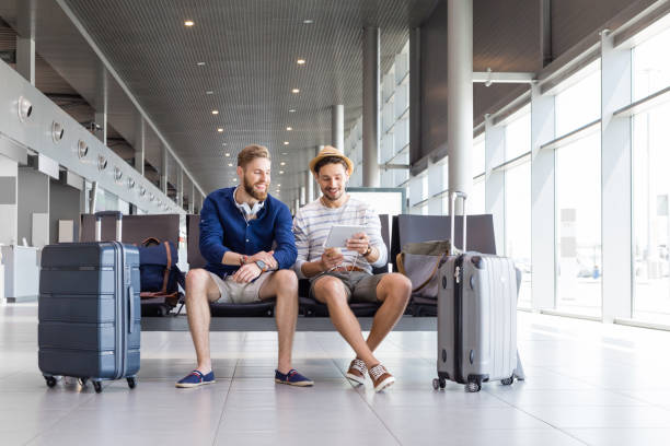istock Friends using digital tablet in airport departure lounge 945558606