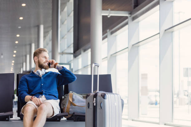 istock Man waiting in airport lounge and making phone call 945563426