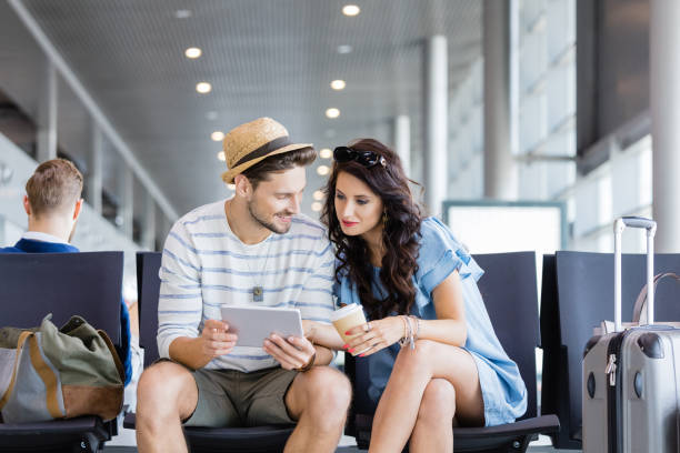 istock Couple using digital tablet at airport lounge 945565008