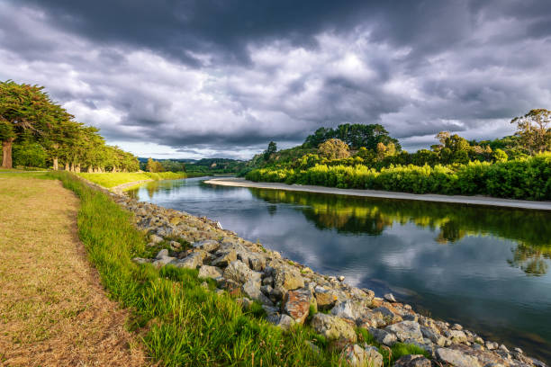On the banks of the river Manawatu On the banks of the river Manawatu in Palmerston North New Zealand under dramatic skies manawatu stock pictures, royalty-free photos & images