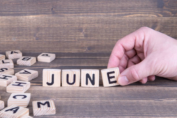 istock June. Wooden letters on the office desk 945574568