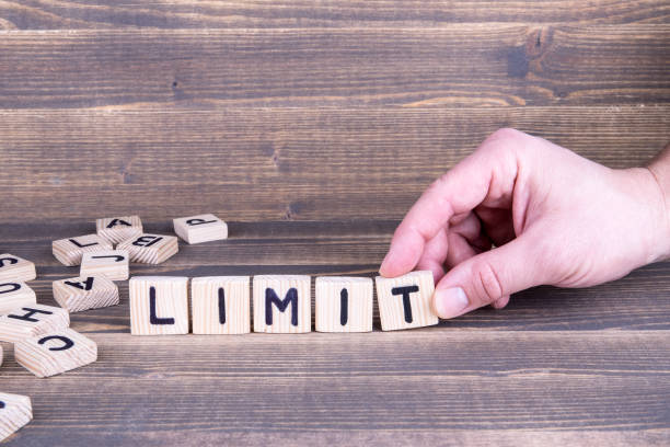 istock Limit. Wooden letters on the office desk 945574598