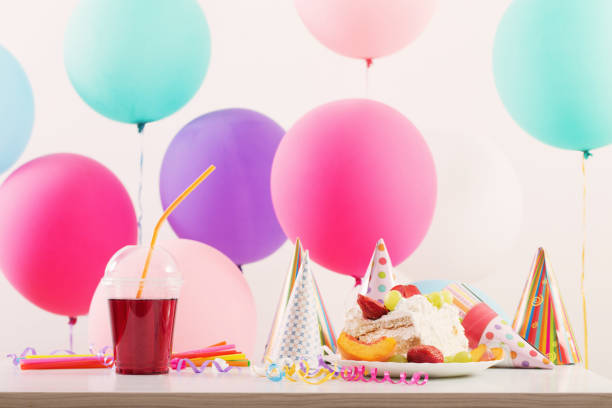 istock Birthday celebration with cake and colorful balloons 945574776