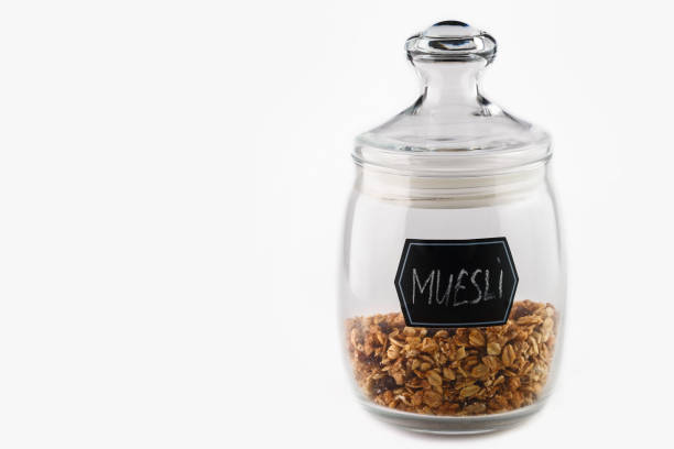 Dry muesli in glass jar on white background. Isolated