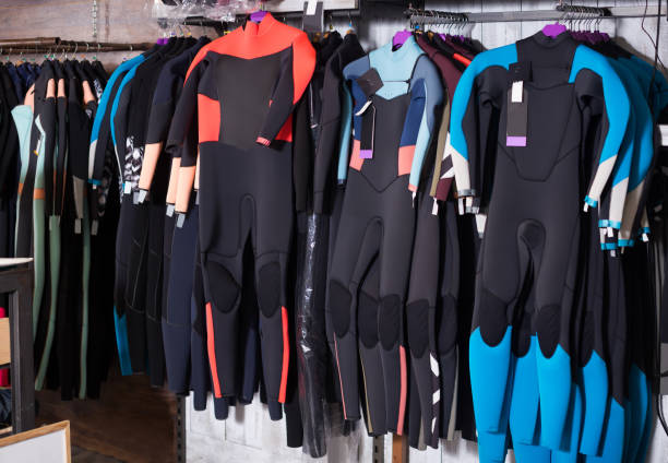 Image of colorful wetsuit hanging in the  store for surfing Image of colorful wetsuit hanging in the modern asian store for surfing wetsuit stock pictures, royalty-free photos & images