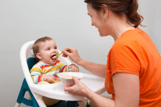 istock Mum spoon-feeds the baby 945592608