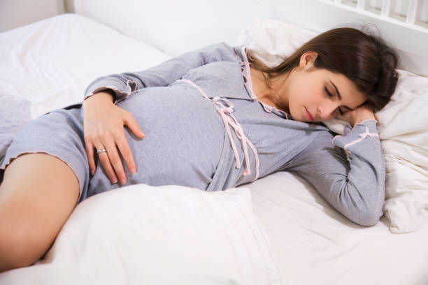 istock Pregnant woman sleeping peaceful in bed closeup 945600372
