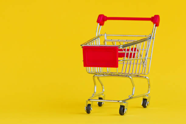 istock Shopping cart isolated on pastel yellow background. 945600954