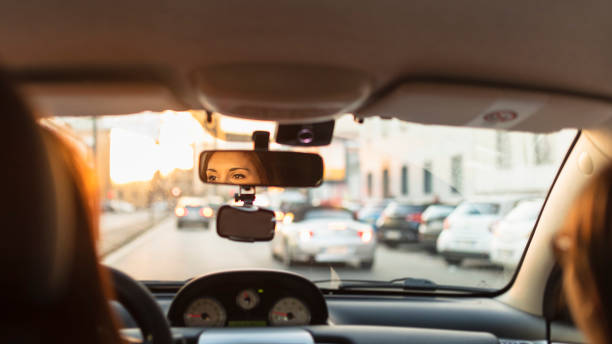 city traffic by car - woman in mirror backview imagens e fotografias de stock