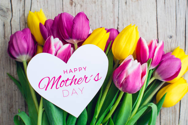 grußkarte - rosa und gelbe tulpen auf einem hölzernen hintergrund - mothers day stock-fotos und bilder