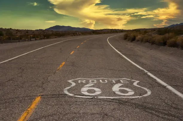 Photo of California: Historic Route 66 with marker on road at sunset