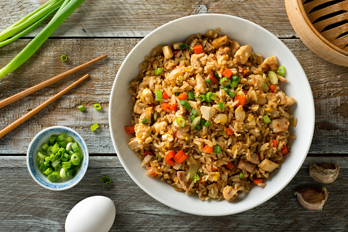 Delicious chicken fried rice with egg, carrot, garlic and green onion.